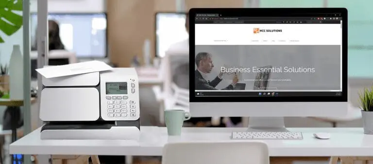 MCC Solutions postage meter page header - Quadient postage meter sitting on a desk with a computer monitor showing the MCC Solutions website