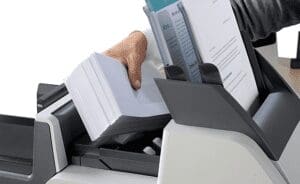 Quadient DS-35 folder inserter with woman's hand adding envelopes