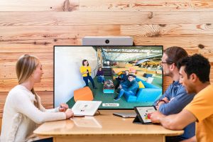 Cisco huddle space with three people sitting around watching a Webex meeting. MCC Office Technology Solutions