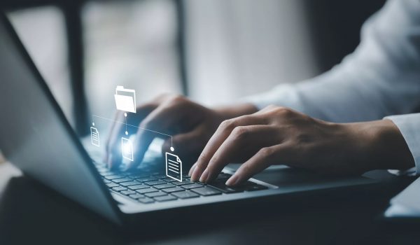 business man typing on a keyboard with holograms of digital document files.