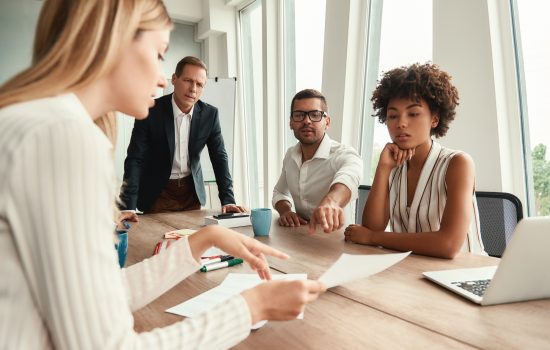 Business meeting. Group of young business people looking at documents and discussing something while