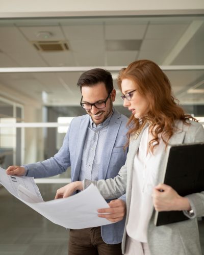 business people looking at blueprints in an office for a security system site survey